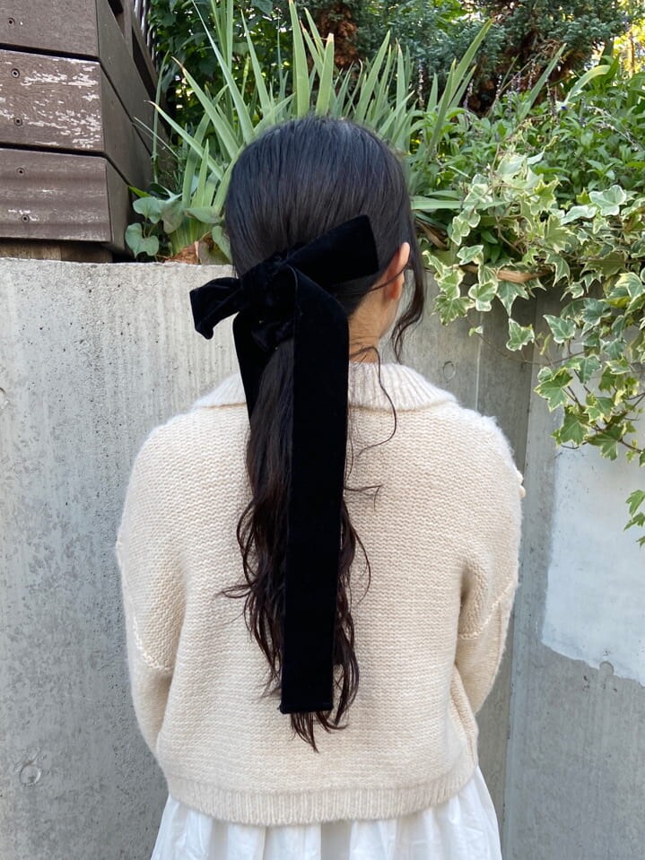 ホワイト系のカーディガン/ボレロ、ブラック系のパンプス、ブラック系のショルダーバッグを着用したレディースの冬コーディネートの4枚目の写真