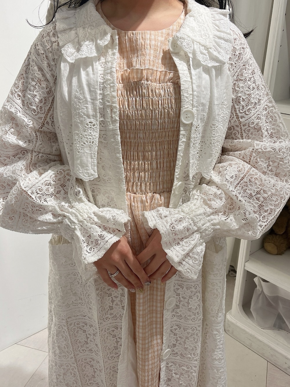 オレンジ系のワンピース、ホワイト系のトレンチコート、ホワイト系のパンプスを着用したレディースの春コーディネートの7枚目の写真