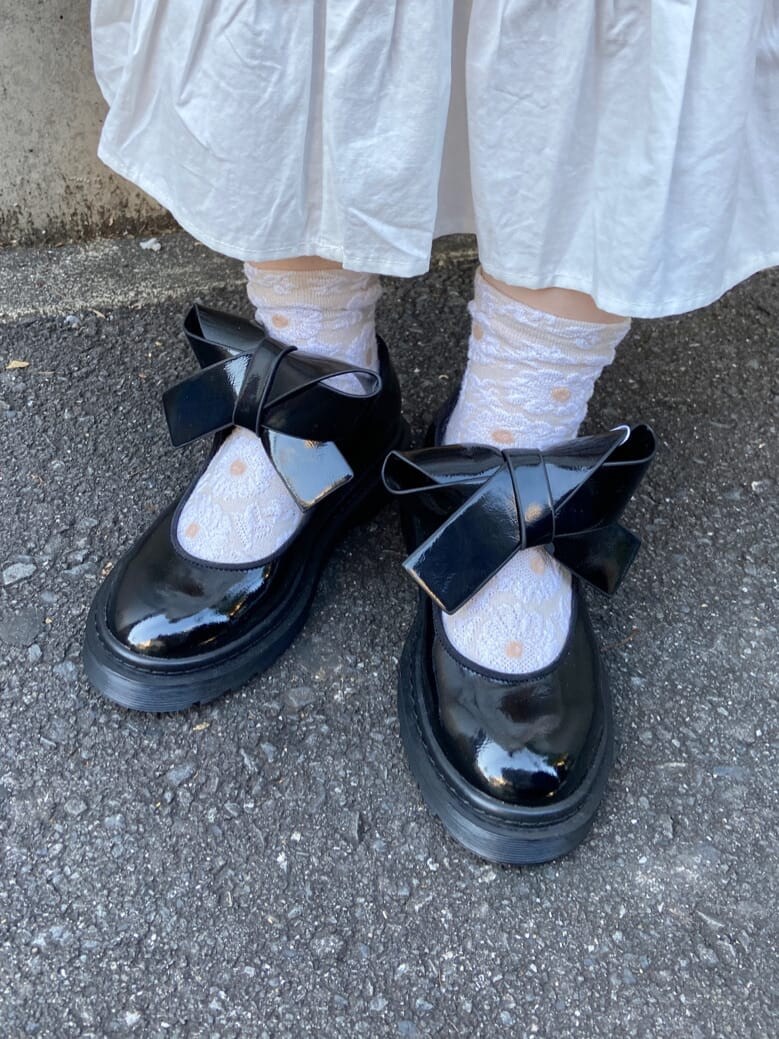 ホワイト系のカーディガン/ボレロ、ブラック系のパンプス、ブラック系のショルダーバッグを着用したレディースの冬コーディネートの6枚目の写真