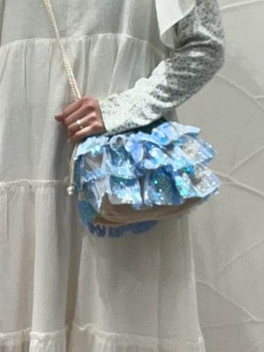 ホワイト系のワンピース、ブルー系のスニーカー、ブルー系のハンドバッグを着用したレディースの冬コーディネートの7枚目の写真