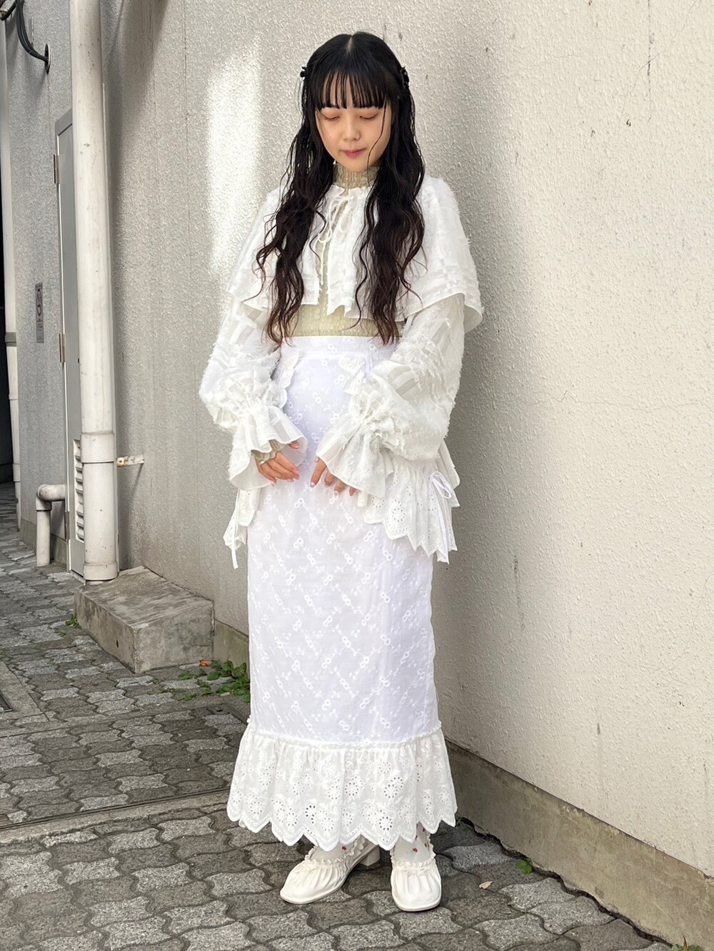 ホワイト系のシャツ/ブラウス、グリーン系のTシャツ/カットソー、ホワイト系のスカートを着用したレディースの冬コーディネートの3枚目の写真