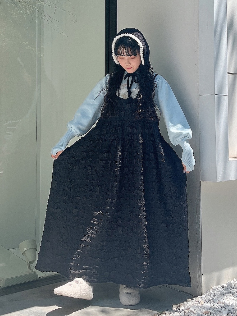 ブルー系のニット/セーター、ブラック系のワンピース、ホワイト系のスリッポンを着用したレディースの夏コーディネートの3枚目の写真