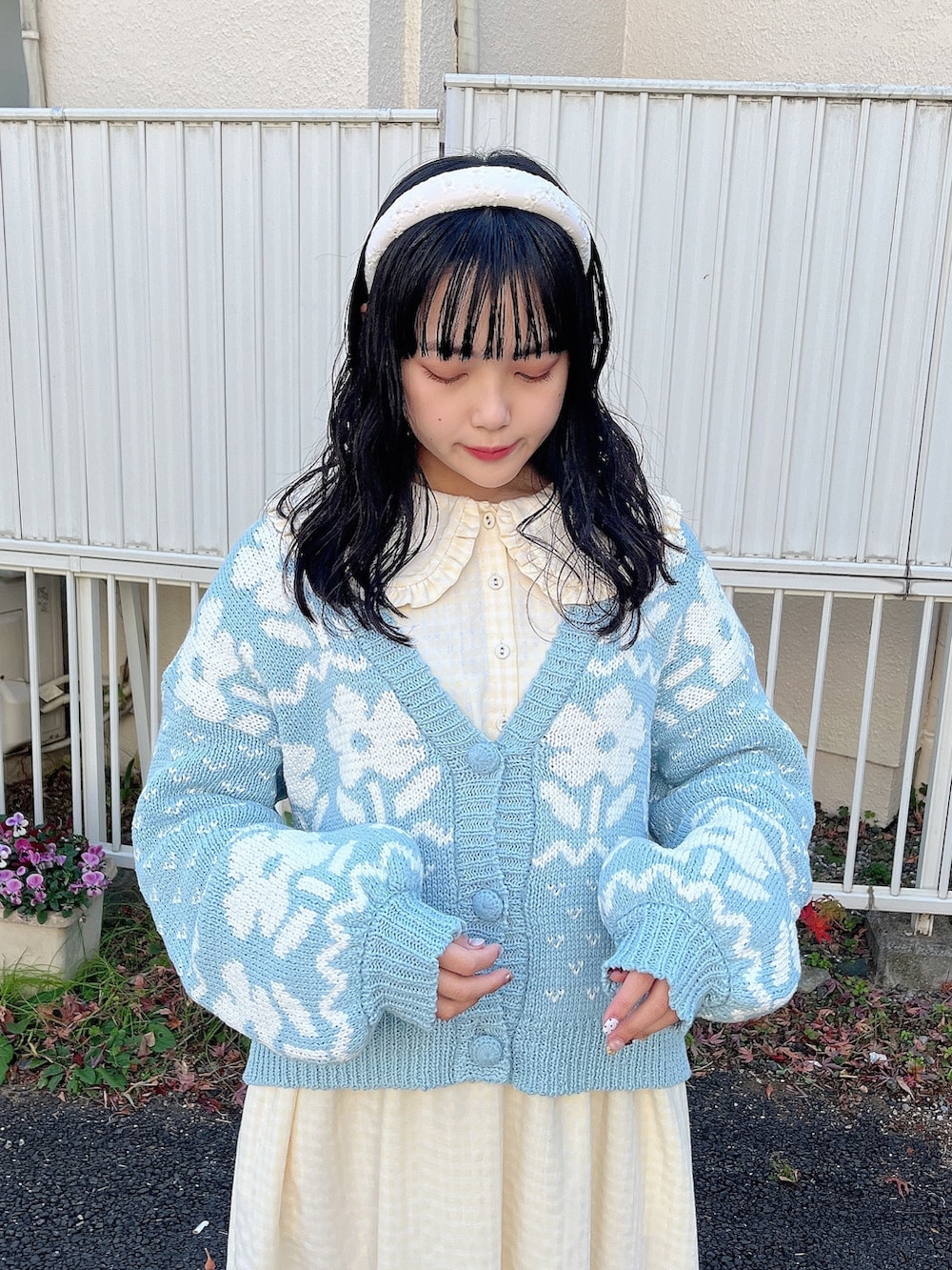 イエロー系のワンピース、ブルー系のカーディガン/ボレロ、ホワイト系のスニーカーを着用したレディースの冬コーディネートの4枚目の写真