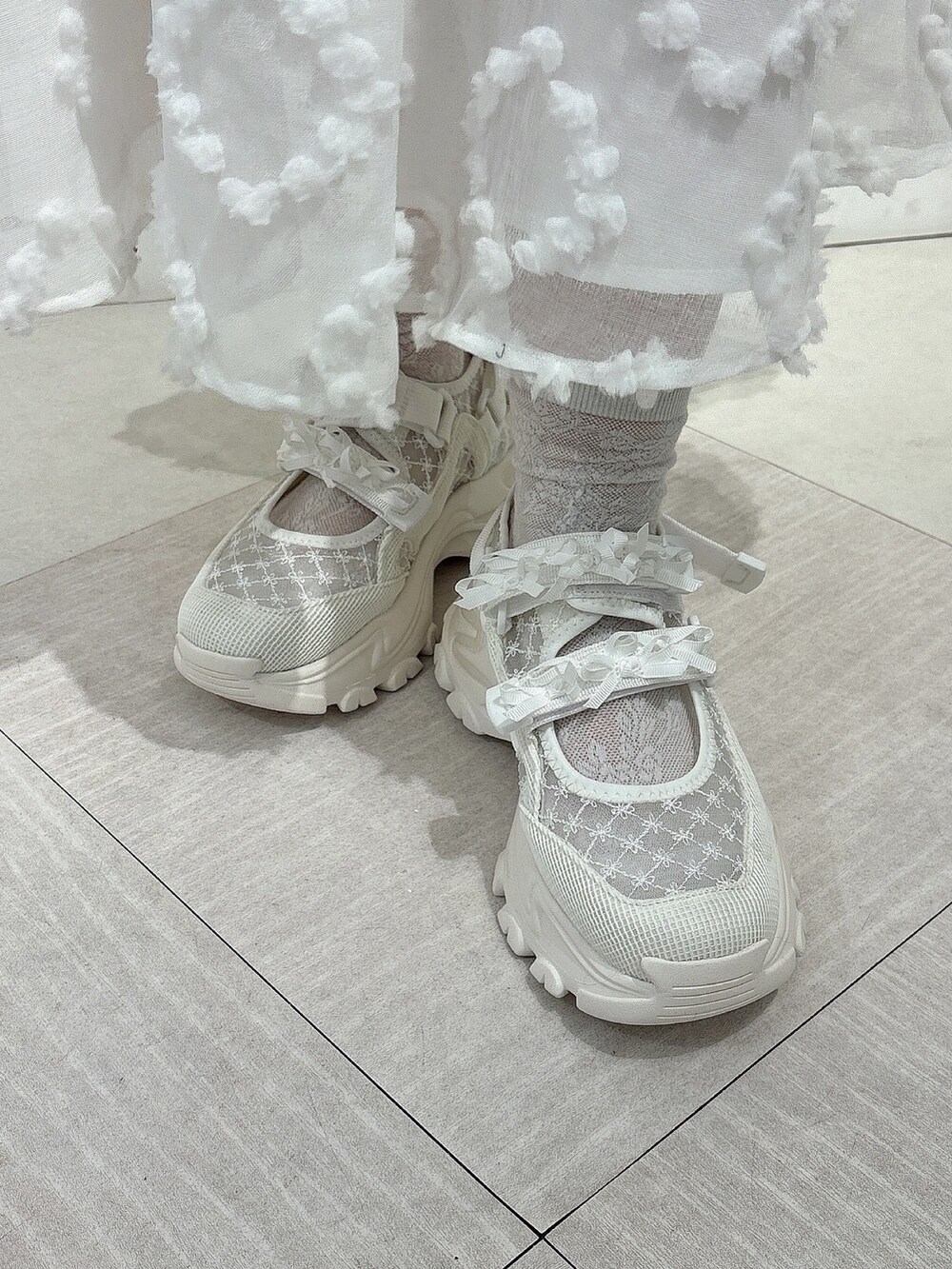 ホワイト系のTシャツ/カットソー、ホワイト系のジャンパースカート、ホワイト系のスニーカーを着用したレディースの春コーディネートの7枚目の写真