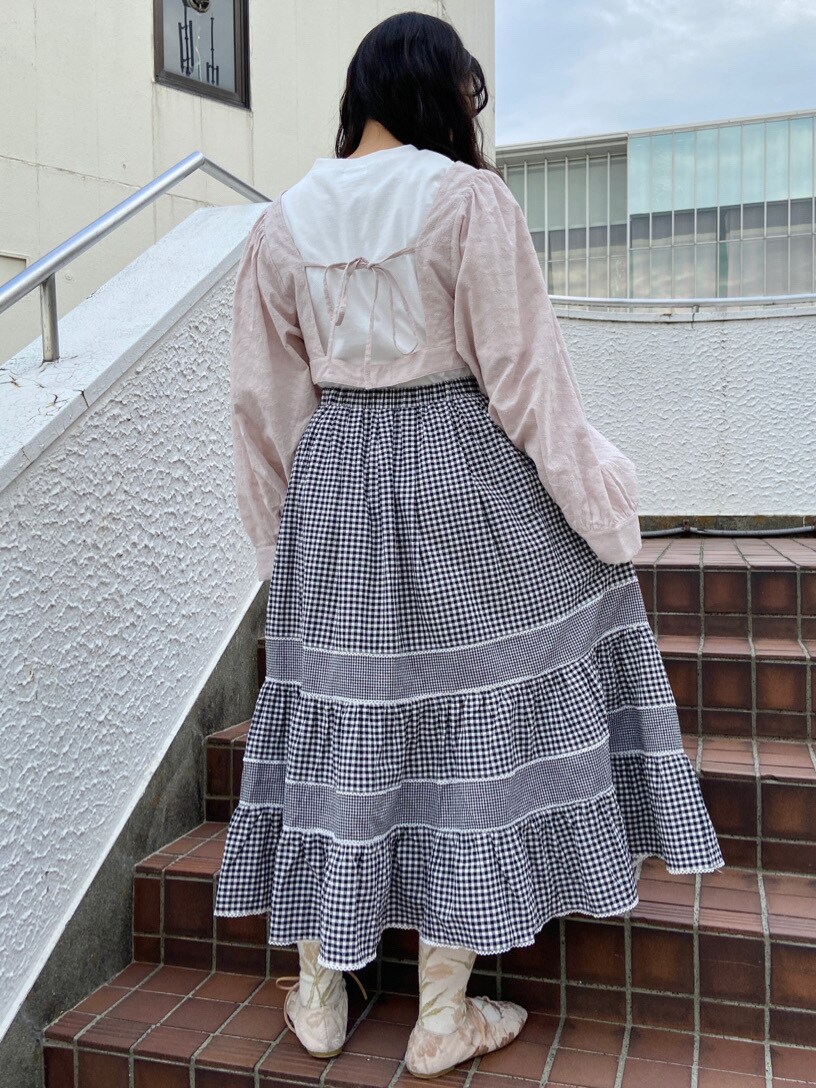 ホワイト系のその他シューズ、ブラック系のスカート、ホワイト系のTシャツ/カットソーを着用したレディースの春コーディネートの2枚目の写真