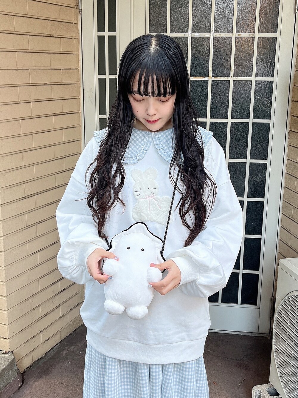 ホワイト系のスウェット、ホワイト系のショルダーバッグ、ブルー系のワンピースを着用したレディースの冬コーディネートの5枚目の写真