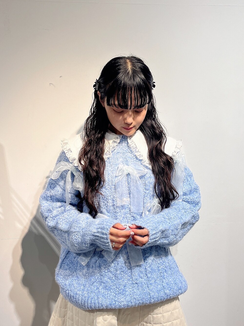 ホワイト系のシャツ/ブラウス、ブルー系のニット/セーター、ホワイト系のスカートを着用したレディースの秋コーディネートの5枚目の写真