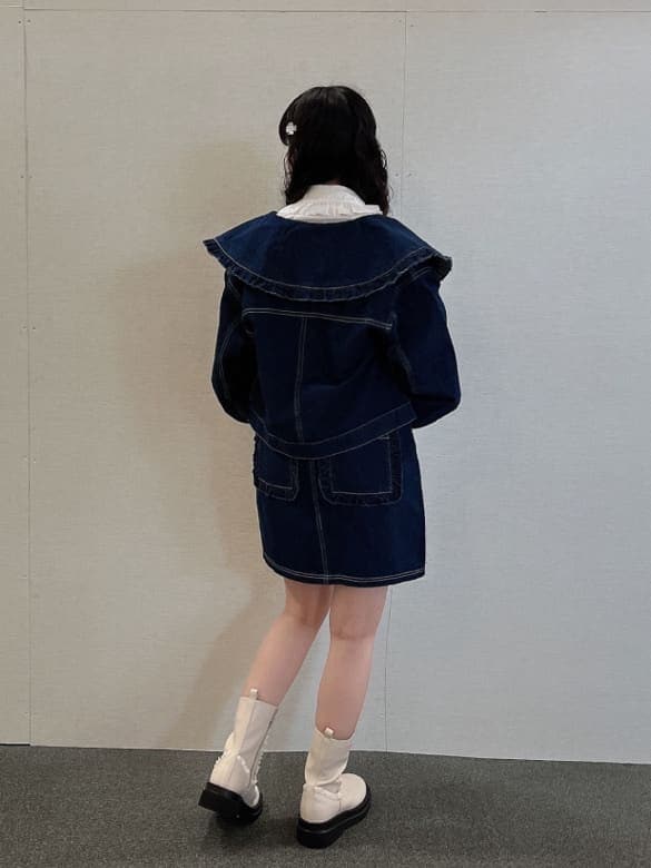 ブルー系のデニムジャケット、ホワイト系のブーツ、ホワイト系のボストンバッグを着用したレディースの夏コーディネートの3枚目の写真