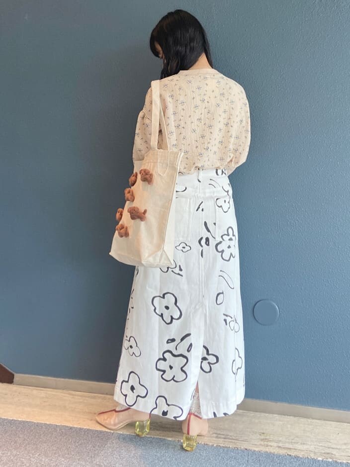 ホワイト系のトートバッグ、ベージュ系のTシャツ/カットソー、ホワイト系のスカートを着用したレディースの夏コーディネートの3枚目の写真