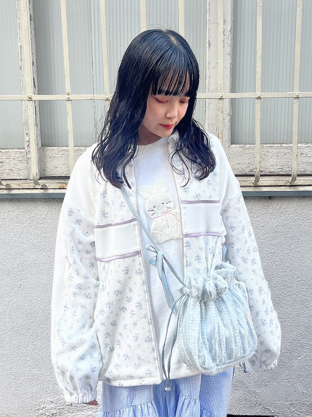 ホワイト系のスウェット、ブルー系のジャージ、ブルー系のショルダーバッグを着用したレディースの春コーディネートの6枚目の写真