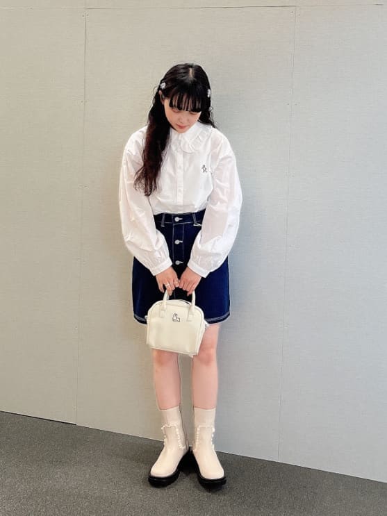 ブルー系のデニムジャケット、ホワイト系のブーツ、ホワイト系のボストンバッグを着用したレディースの夏コーディネートの6枚目の写真