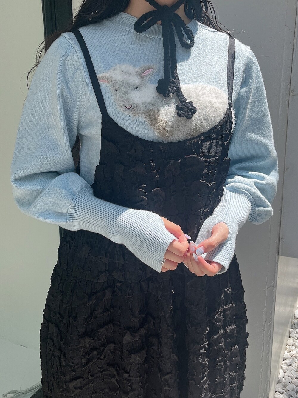 ブルー系のニット/セーター、ブラック系のワンピース、ホワイト系のスリッポンを着用したレディースの夏コーディネートの8枚目の写真