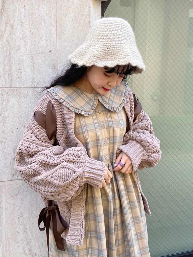 ベージュ系のワンピース、ホワイト系のパンプス、ブラウン系のカーディガン/ボレロを着用したレディースの秋コーディネートの4枚目の写真