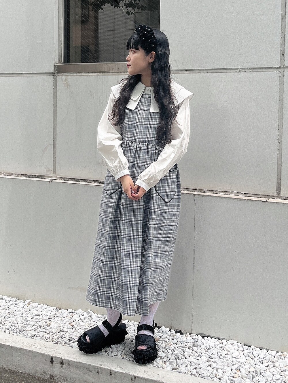 ブラック系のワンピース、ホワイト系のシャツ/ブラウス、ブラック系のサンダルを着用したレディースの夏コーディネートの2枚目の写真
