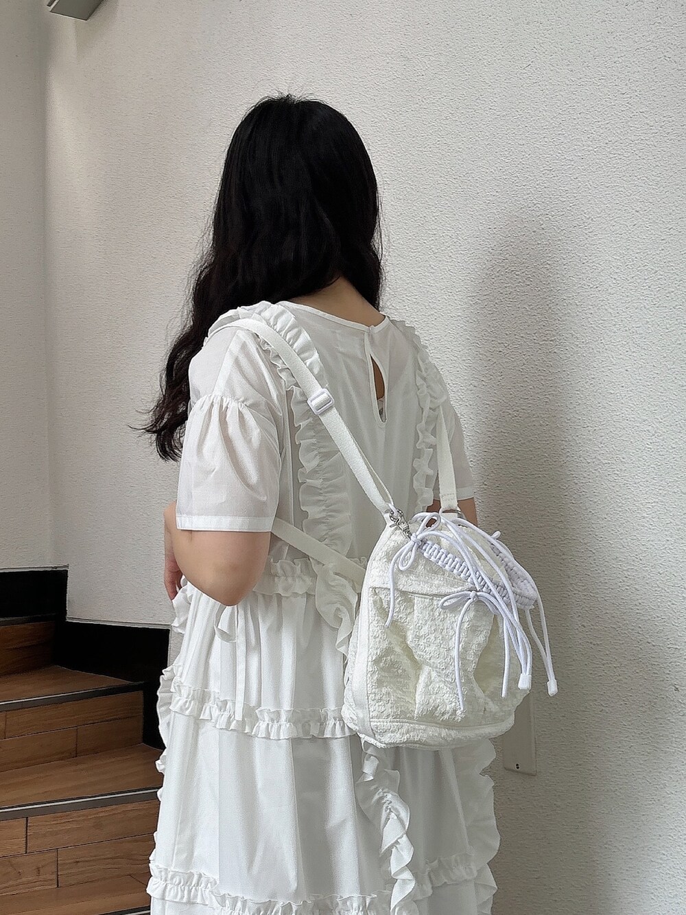 ホワイト系のスニーカー、ホワイト系のワンピース、ホワイト系のショルダーバッグを着用したレディースの夏コーディネートの6枚目の写真