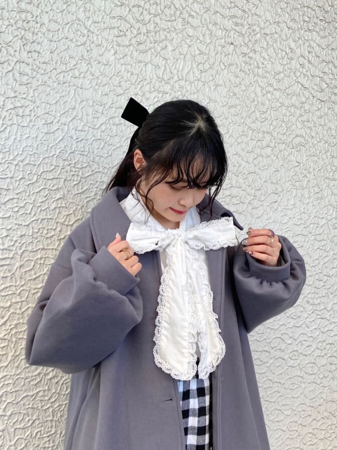 ブルー系のステンカラーコート、ホワイト系のシャツ/ブラウス、ブラック系のスカートを着用したレディースの秋コーディネートの3枚目の写真