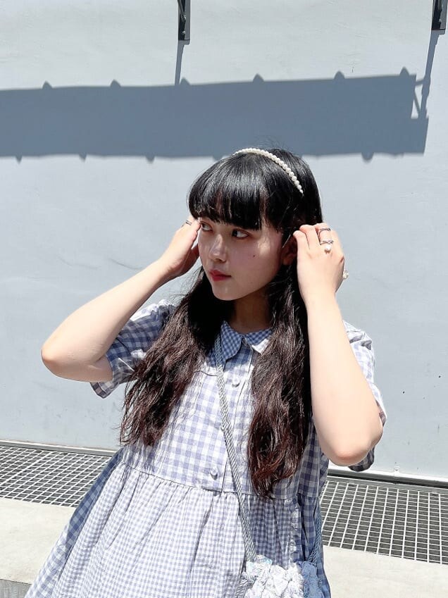 ホワイト系のサンダル、パープル系のハンドバッグ、パープル系のワンピースを着用したレディースの夏コーディネートの3枚目の写真