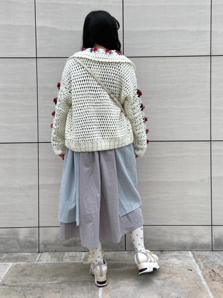 ホワイト系のカーディガン/ボレロ、ホワイト系のスニーカー、グレー系のワンピースを着用したレディースの冬コーディネートの2枚目の写真