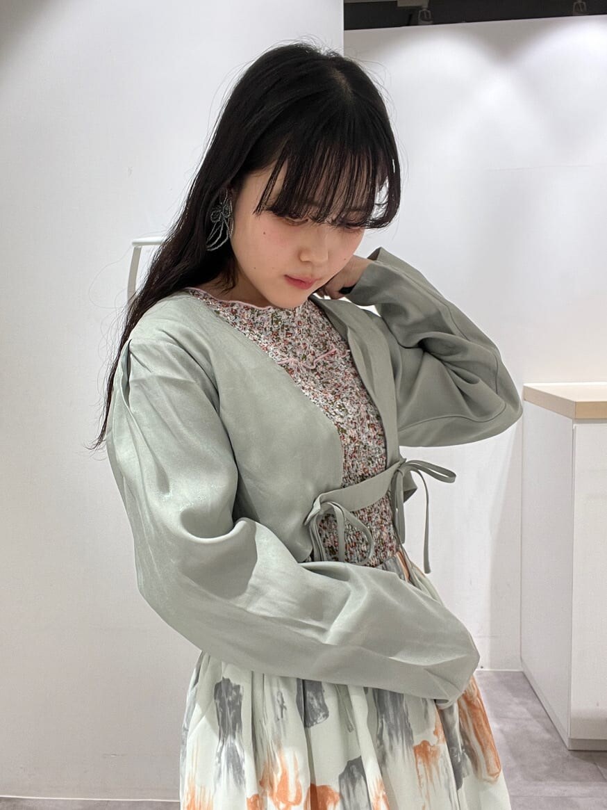 グリーン系のカーディガン/ボレロ、グリーン系のスカート、グリーン系のパンプスを着用したレディースの春コーディネートの4枚目の写真