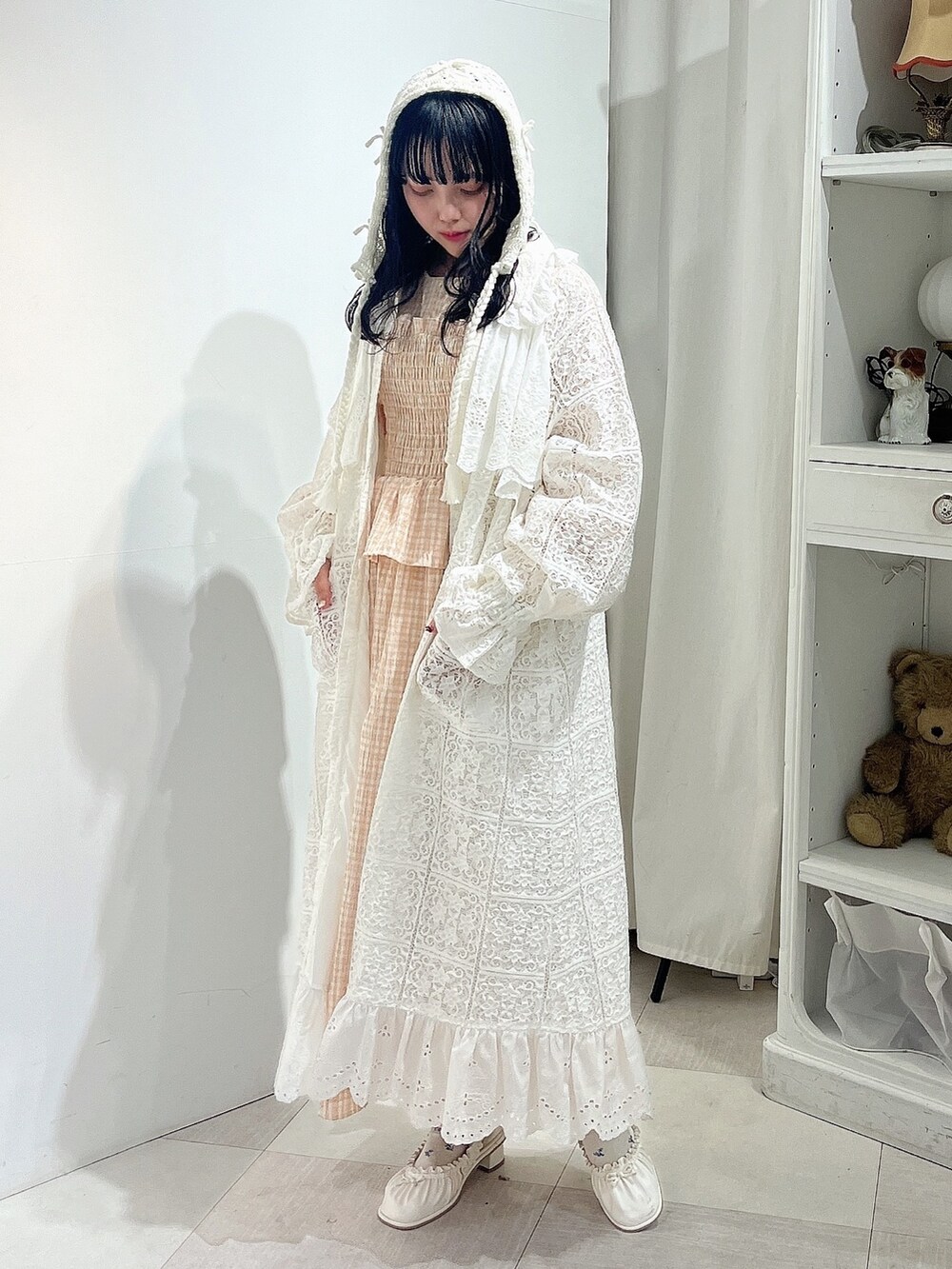 オレンジ系のワンピース、ホワイト系のトレンチコート、ホワイト系のパンプスを着用したレディースの春コーディネートの3枚目の写真