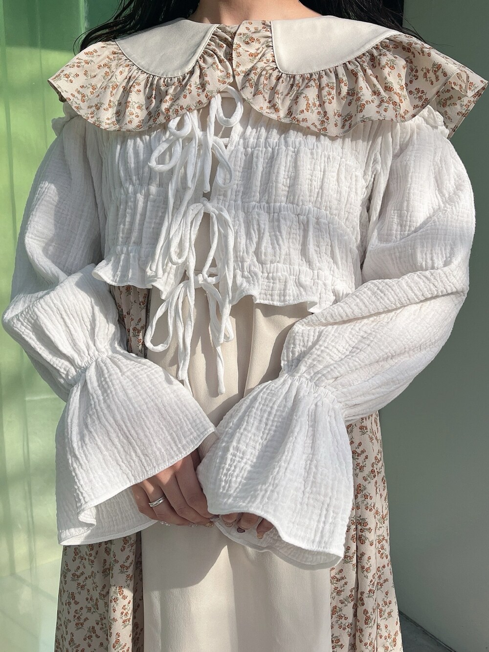 ベージュ系のワンピース、ホワイト系のシャツ/ブラウス、ホワイト系のショルダーバッグを着用したレディースの冬コーディネートの6枚目の写真