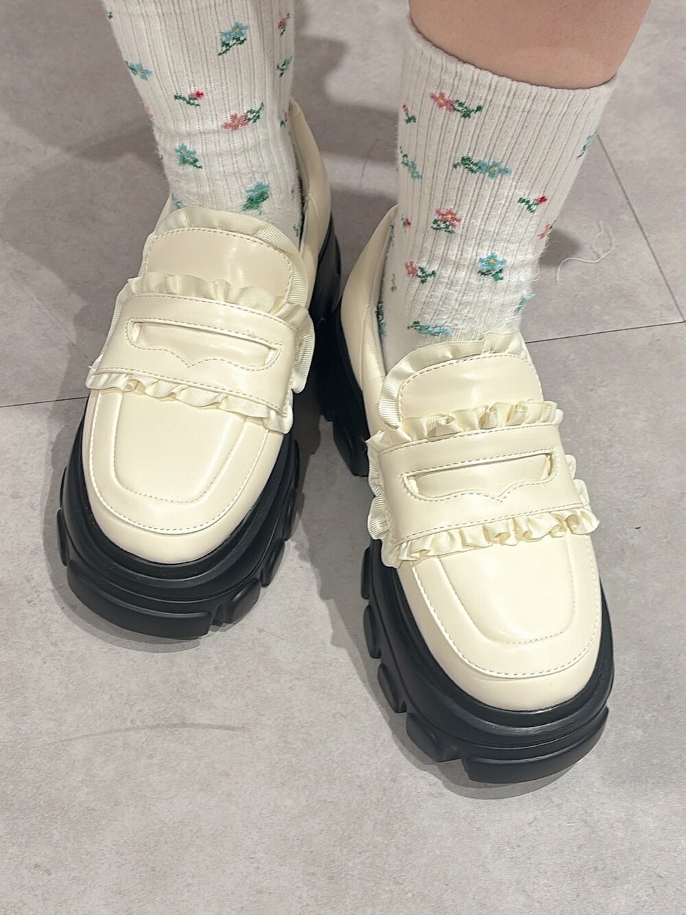 ホワイト系のニット/セーター、ホワイト系のスウェット、ブラック系のスカートを着用したレディースの秋コーディネートの7枚目の写真