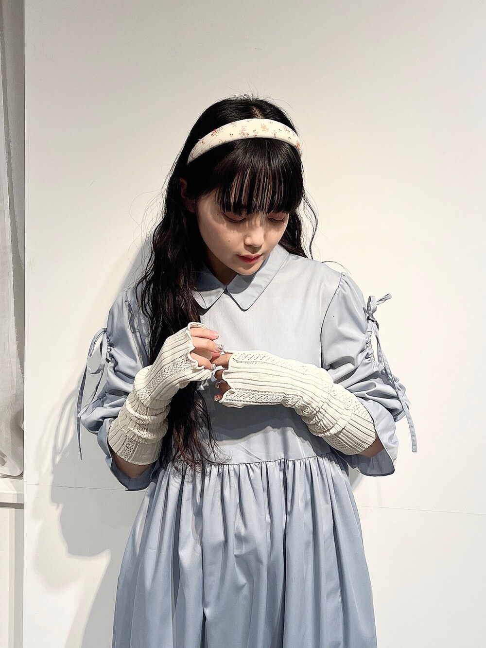 ブルー系のワンピース、ホワイト系のパンプス、ホワイト系のニット/セーターを着用したレディースの春コーディネートの5枚目の写真