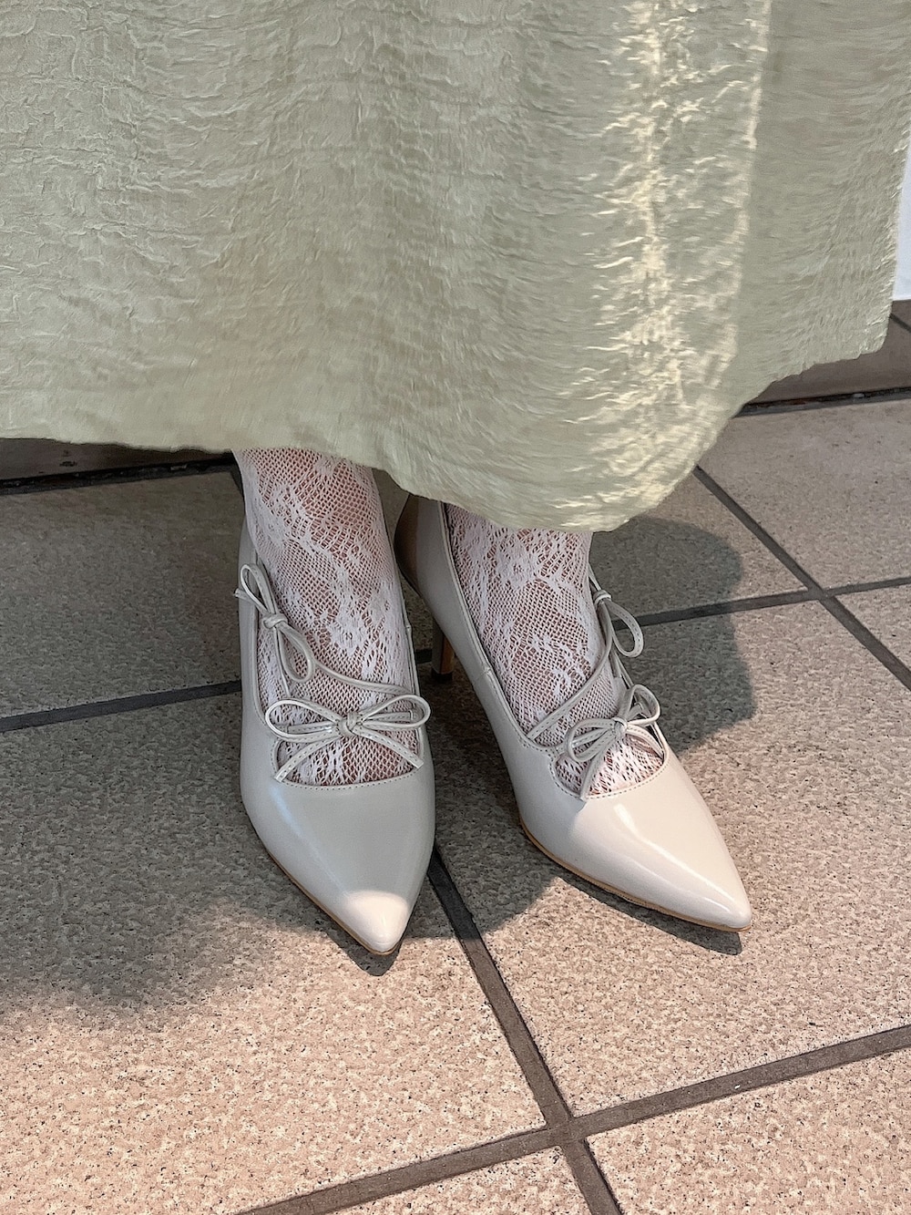 グリーン系のワンピース、ホワイト系のパンプス、ホワイト系のTシャツ/カットソーを着用したレディースの冬コーディネートの6枚目の写真