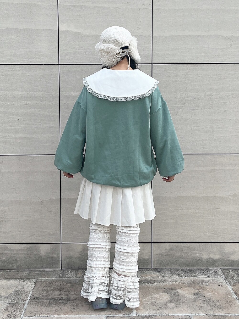 グリーン系のスウェット、ホワイト系のワンピース、ホワイト系のスウェットパンツを着用したレディースの秋コーディネートの3枚目の写真