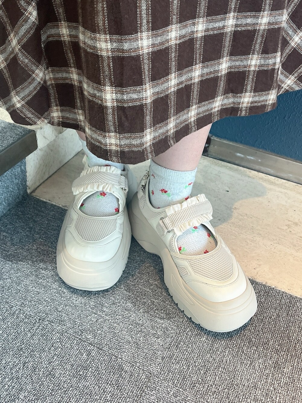 ブラウン系のワンピース、ホワイト系のカーディガン/ボレロ、ホワイト系のスニーカーを着用したレディースの冬コーディネートの6枚目の写真