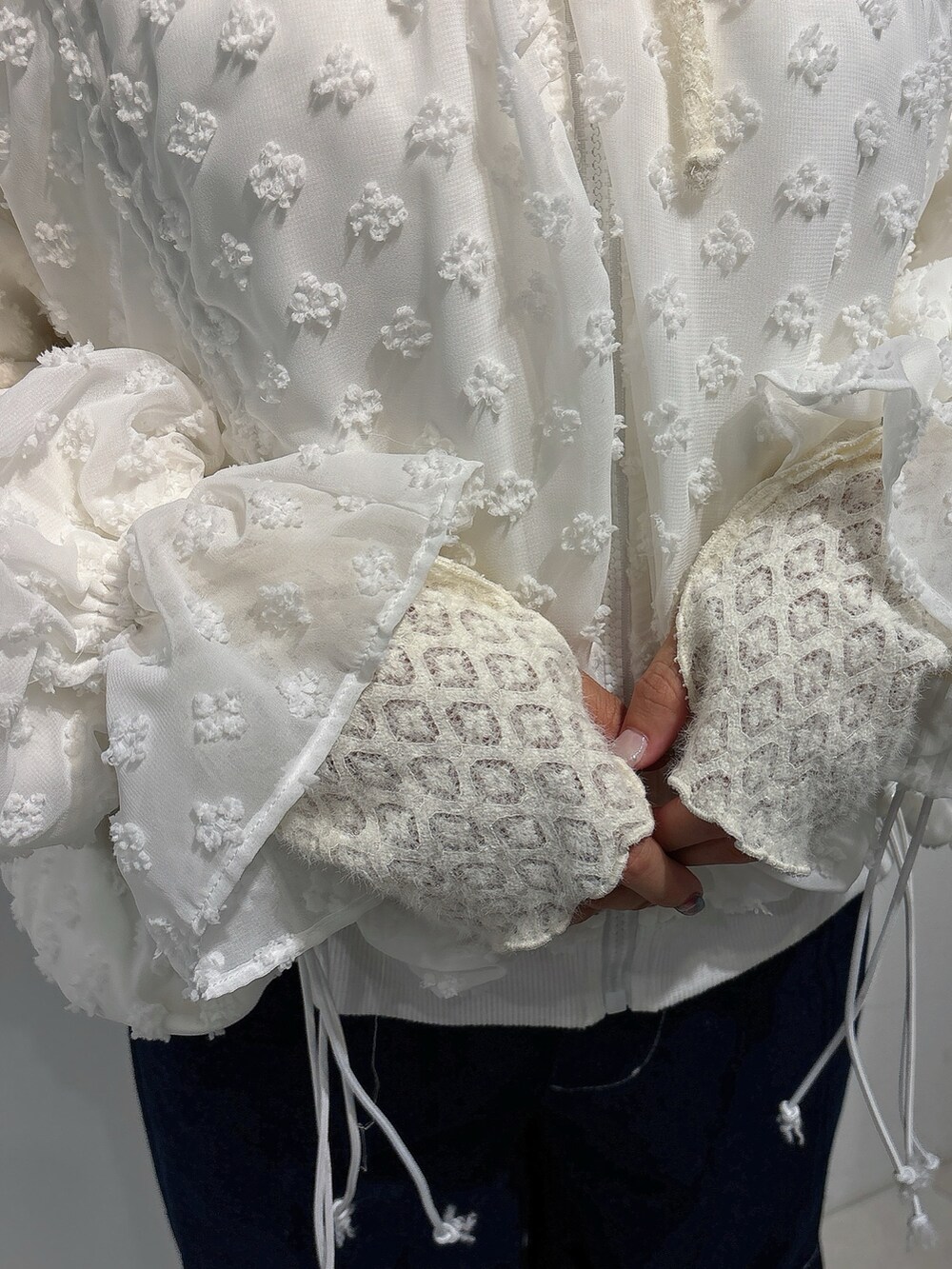 ホワイト系のジャージ、ブルー系のデニムパンツ、ホワイト系のスニーカーを着用したレディースの秋コーディネートの8枚目の写真