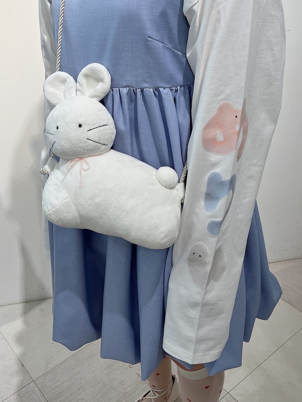 ホワイト系のTシャツ/カットソー、ホワイト系のショルダーバッグ、ブルー系のワンピースを着用したレディースの冬コーディネートの8枚目の写真
