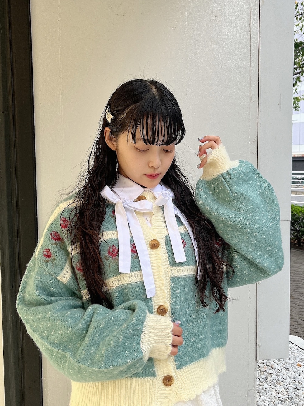 グリーン系のカーディガン/ボレロ、ホワイト系のシャツ/ブラウス、ホワイト系のスカートを着用したレディースの秋コーディネートの4枚目の写真