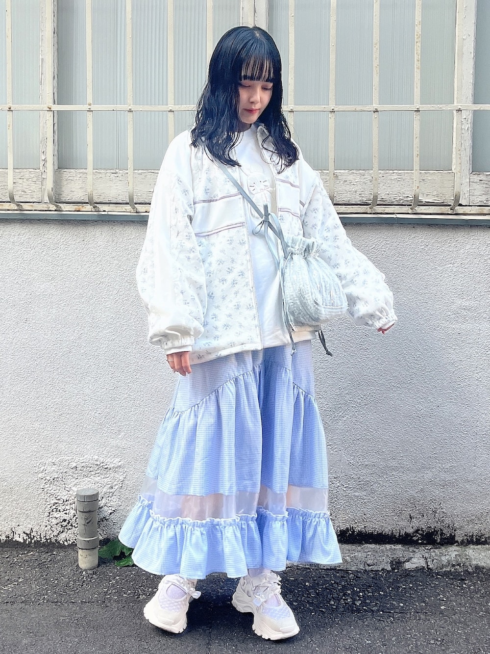 ホワイト系のスウェット、ブルー系のジャージ、ブルー系のショルダーバッグを着用したレディースの春コーディネートの3枚目の写真