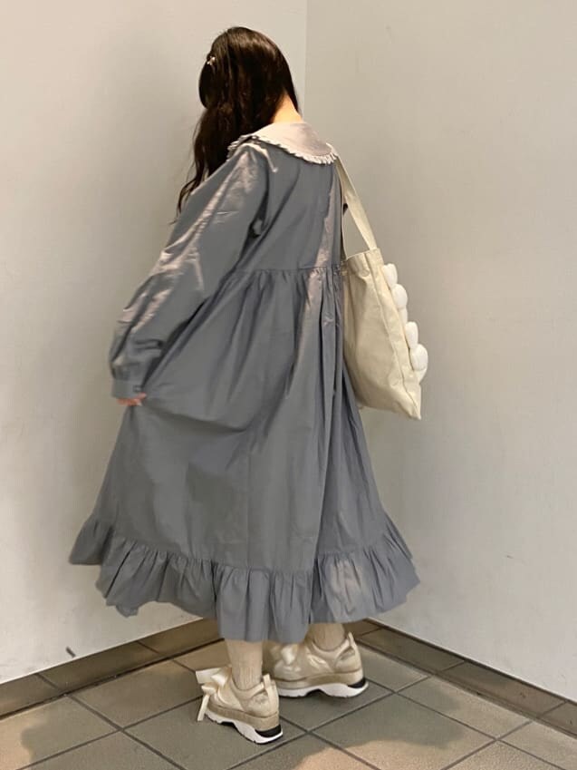 ブルー系のワンピース、ホワイト系のスニーカー、ホワイト系のトートバッグを着用したレディースの冬コーディネートの2枚目の写真