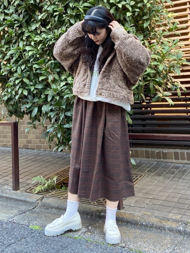 ブラウン系のカバーオール、ブラウン系のワンピース、ホワイト系のローファーを着用したレディースの冬コーディネートの2枚目の写真