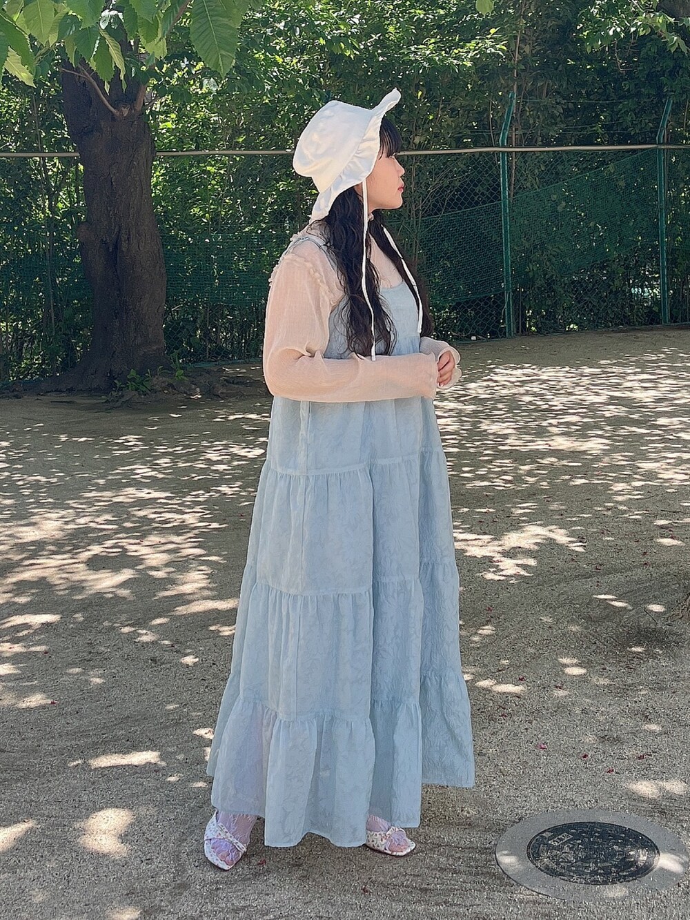 ブルー系のワンピース、ベージュ系のTシャツ/カットソー、ホワイト系のパンプスを着用したレディースの夏コーディネートの2枚目の写真
