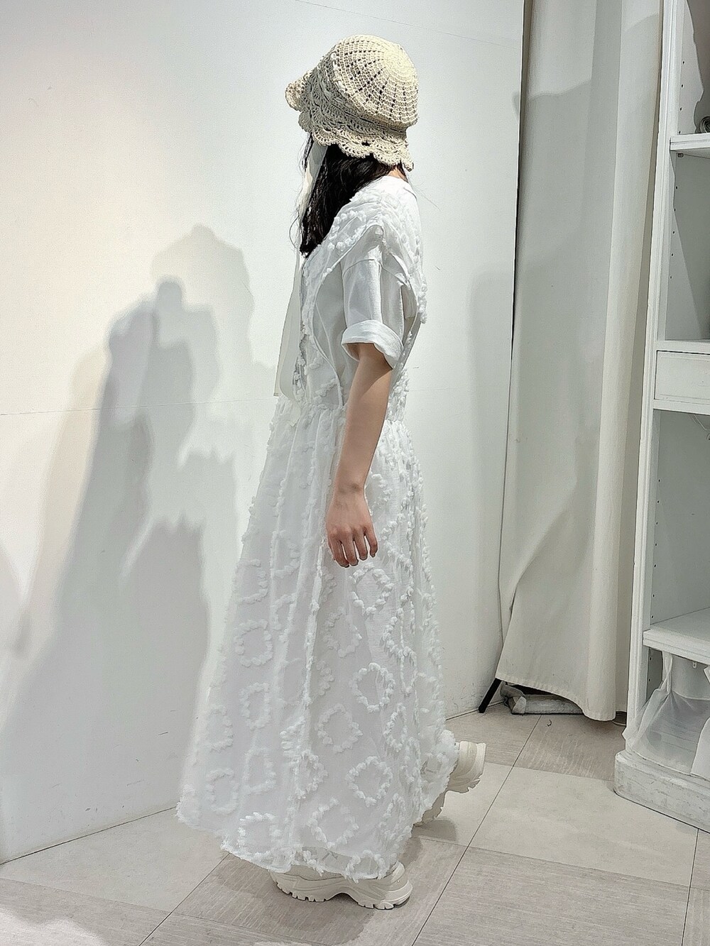 ホワイト系のTシャツ/カットソー、ホワイト系のジャンパースカート、ホワイト系のスニーカーを着用したレディースの春コーディネートの3枚目の写真