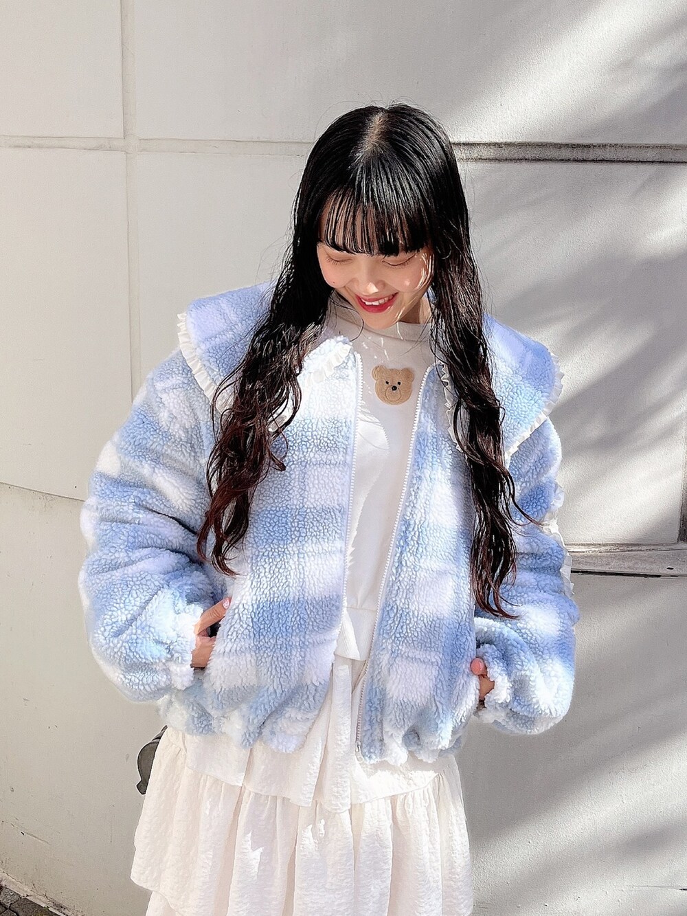 ホワイト系のスウェット、ブルー系のブルゾン、ホワイト系のスカートを着用したレディースの冬コーディネートの6枚目の写真