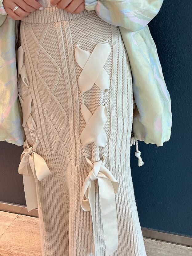 ホワイト系のブーツ、グリーン系のその他アウター、ホワイト系のスカートを着用したレディースの秋コーディネートの6枚目の写真