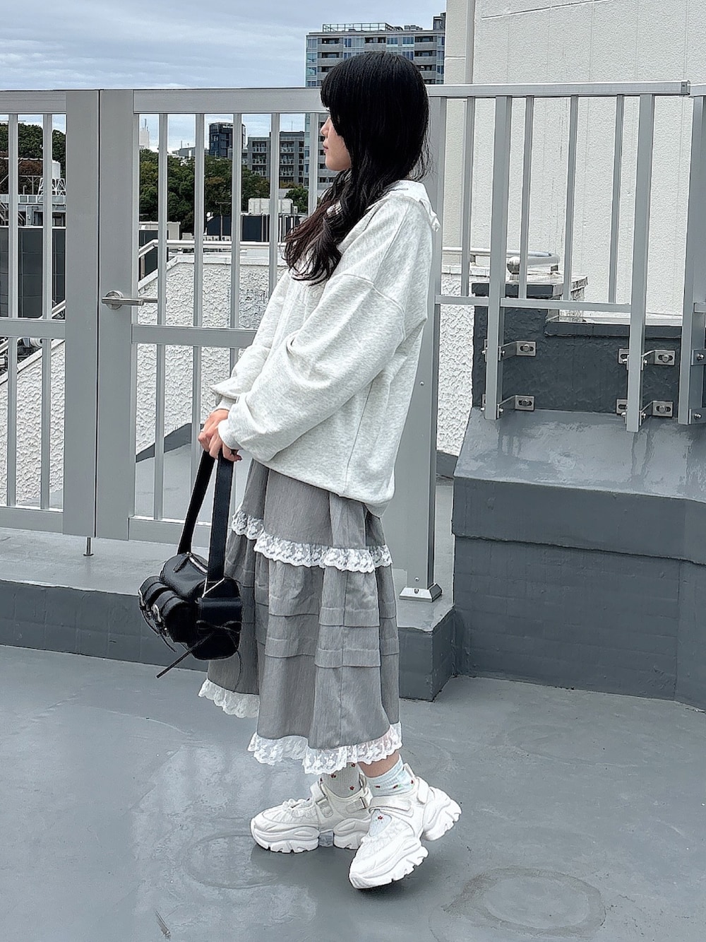 ホワイト系のシャツ/ブラウス、グレー系のスウェット、ブラック系のショルダーバッグを着用したレディースの秋コーディネートの3枚目の写真