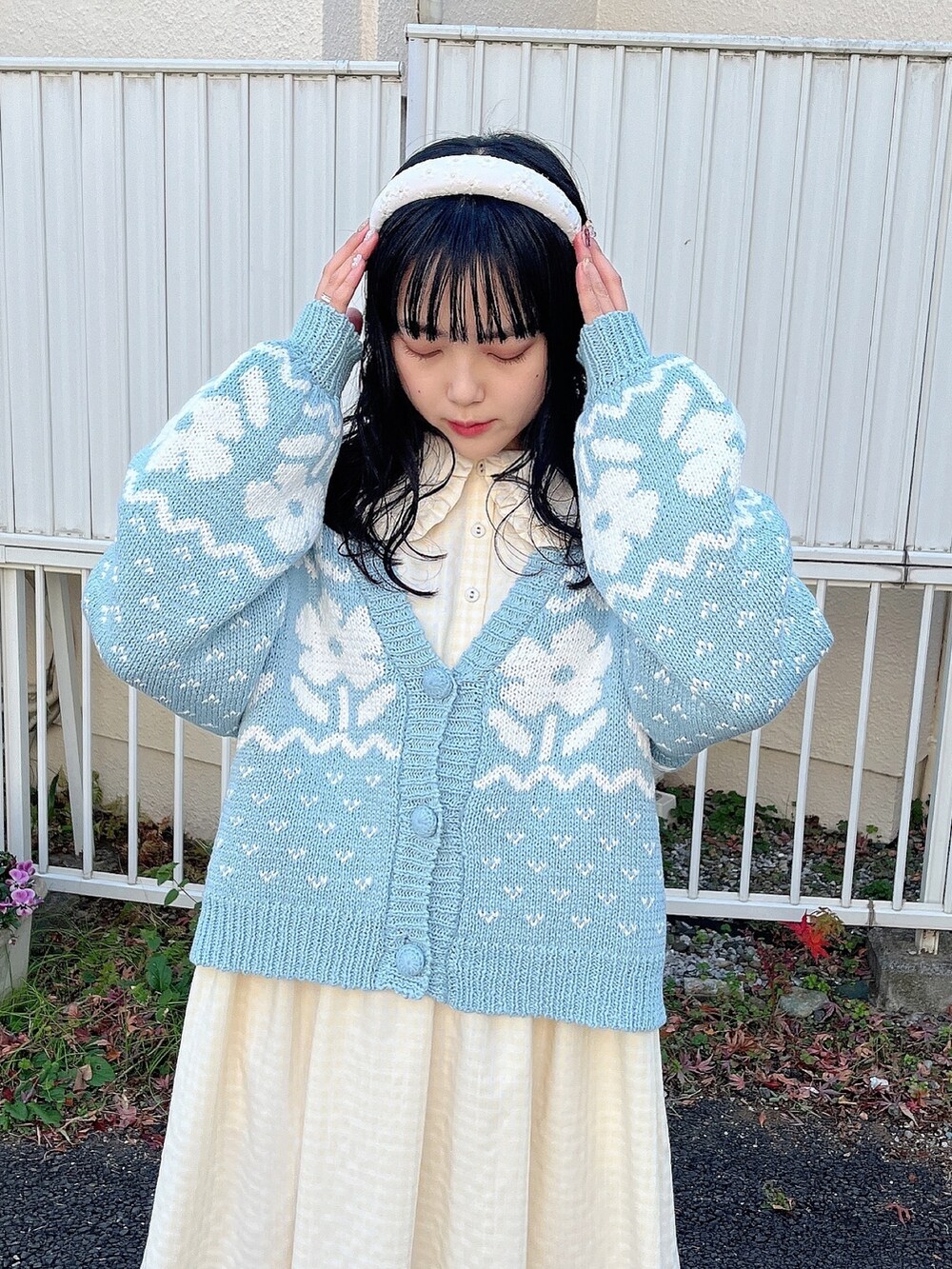 イエロー系のワンピース、ブルー系のカーディガン/ボレロ、ホワイト系のスニーカーを着用したレディースの冬コーディネートの5枚目の写真