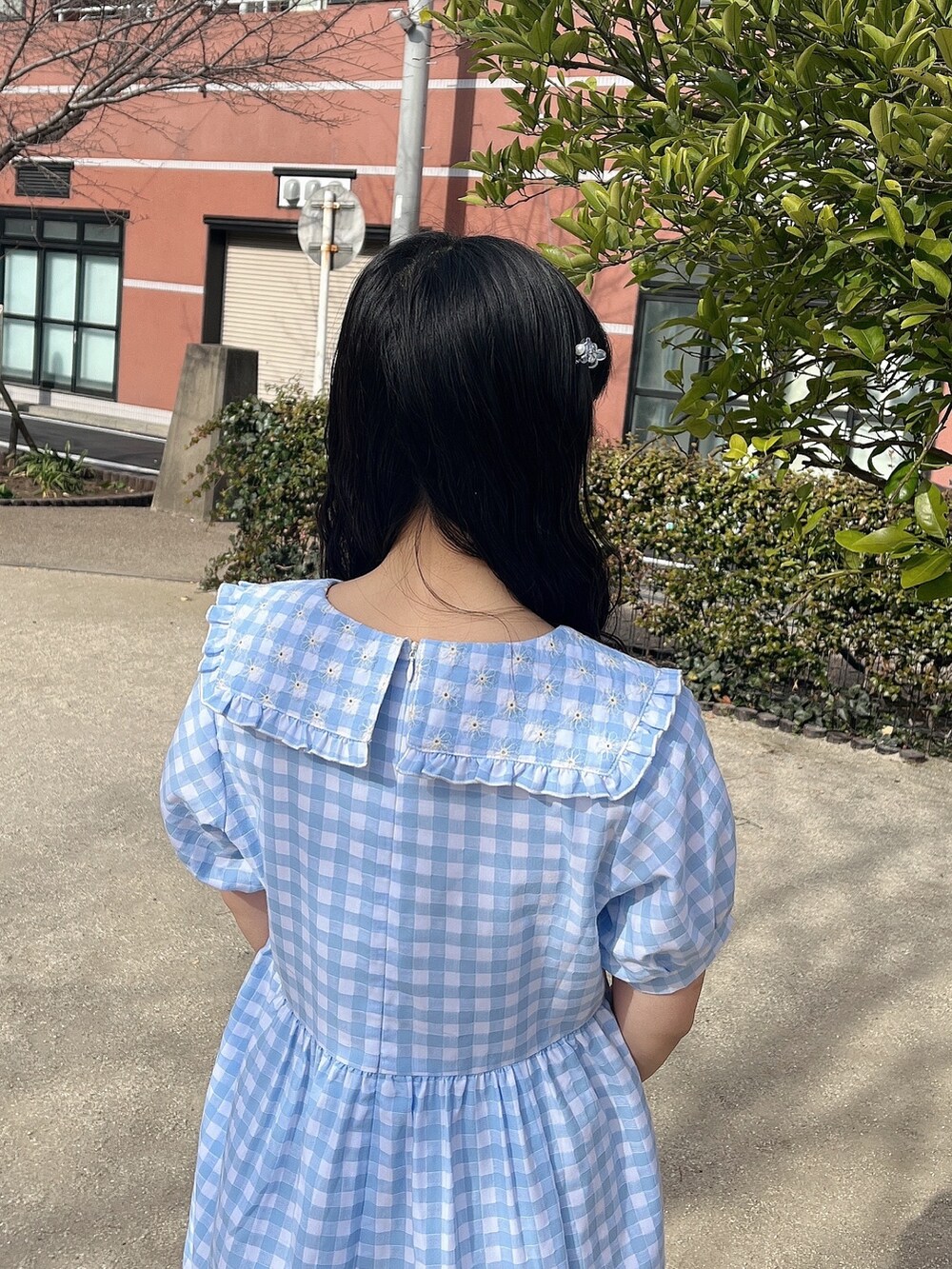 ホワイト系のトートバッグ、ブルー系のワンピース、ホワイト系のスニーカーを着用したレディースの冬コーディネートの5枚目の写真