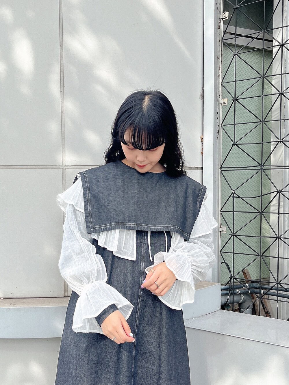 ブラック系のワンピース、ホワイト系のパンプス、ホワイト系のシャツ/ブラウスを着用したレディースの秋コーディネートの3枚目の写真