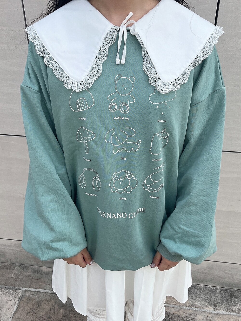 グリーン系のスウェット、ホワイト系のワンピース、ホワイト系のスウェットパンツを着用したレディースの秋コーディネートの5枚目の写真