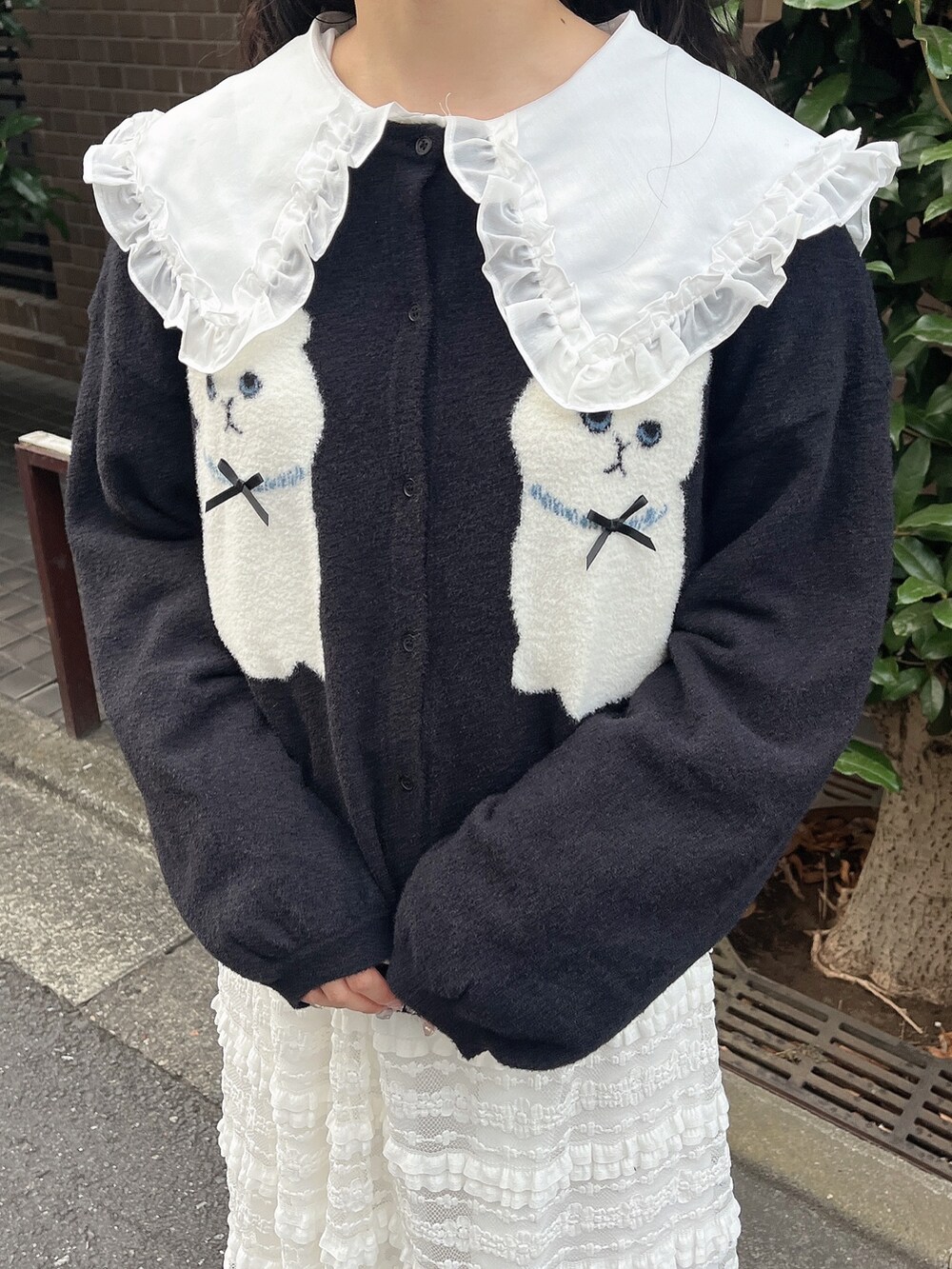 ホワイト系のシャツ/ブラウス、ブラック系のカーディガン/ボレロ、ホワイト系のスカートを着用したレディースの夏コーディネートの5枚目の写真