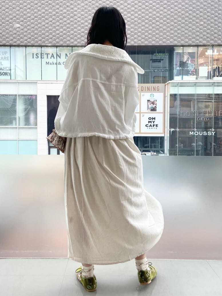 ホワイト系のテーラードジャケット、オレンジ系のハンドバッグ、ホワイト系のワンピースを着用したレディースの夏コーディネートの3枚目の写真