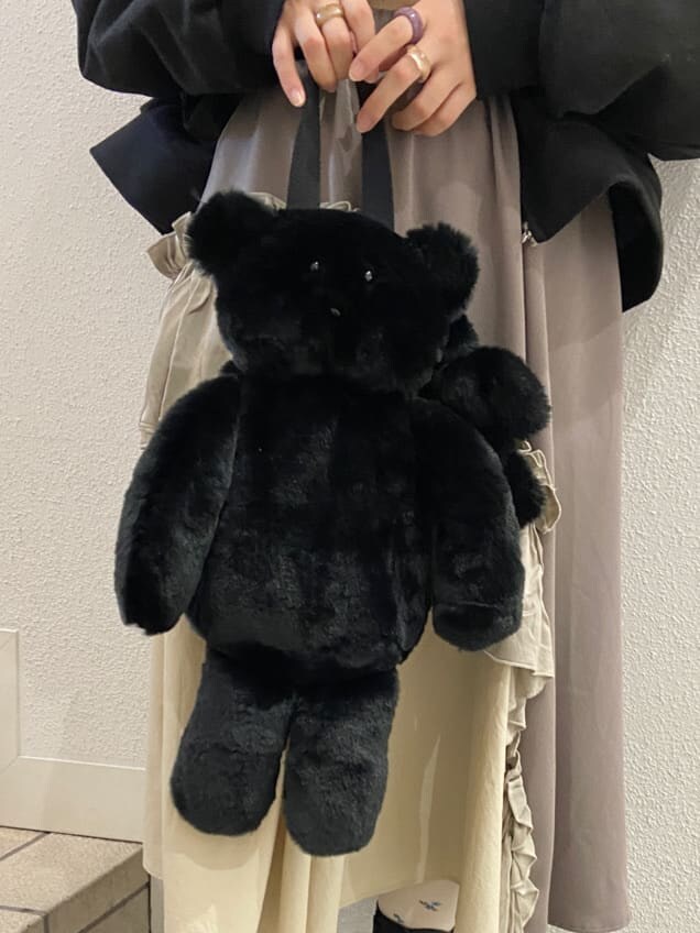 ブラック系のハンドバッグ、ブラック系のブーツ、ベージュ系のスカートを着用したレディースの冬コーディネートの9枚目の写真