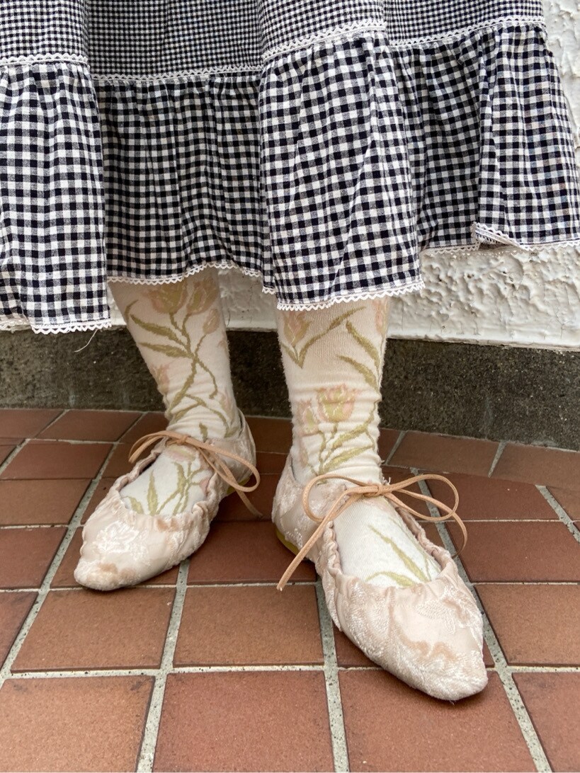 ホワイト系のその他シューズ、ブラック系のスカート、ホワイト系のTシャツ/カットソーを着用したレディースの春コーディネートの5枚目の写真