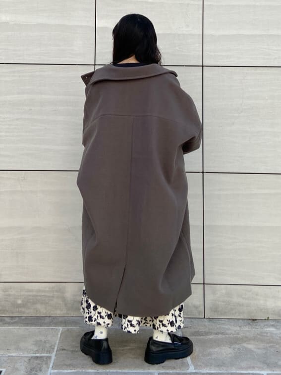 グリーン系のチェスターコート、ブラック系のシャツ/ブラウス、ブラック系のローファーを着用したレディースの冬コーディネートの2枚目の写真